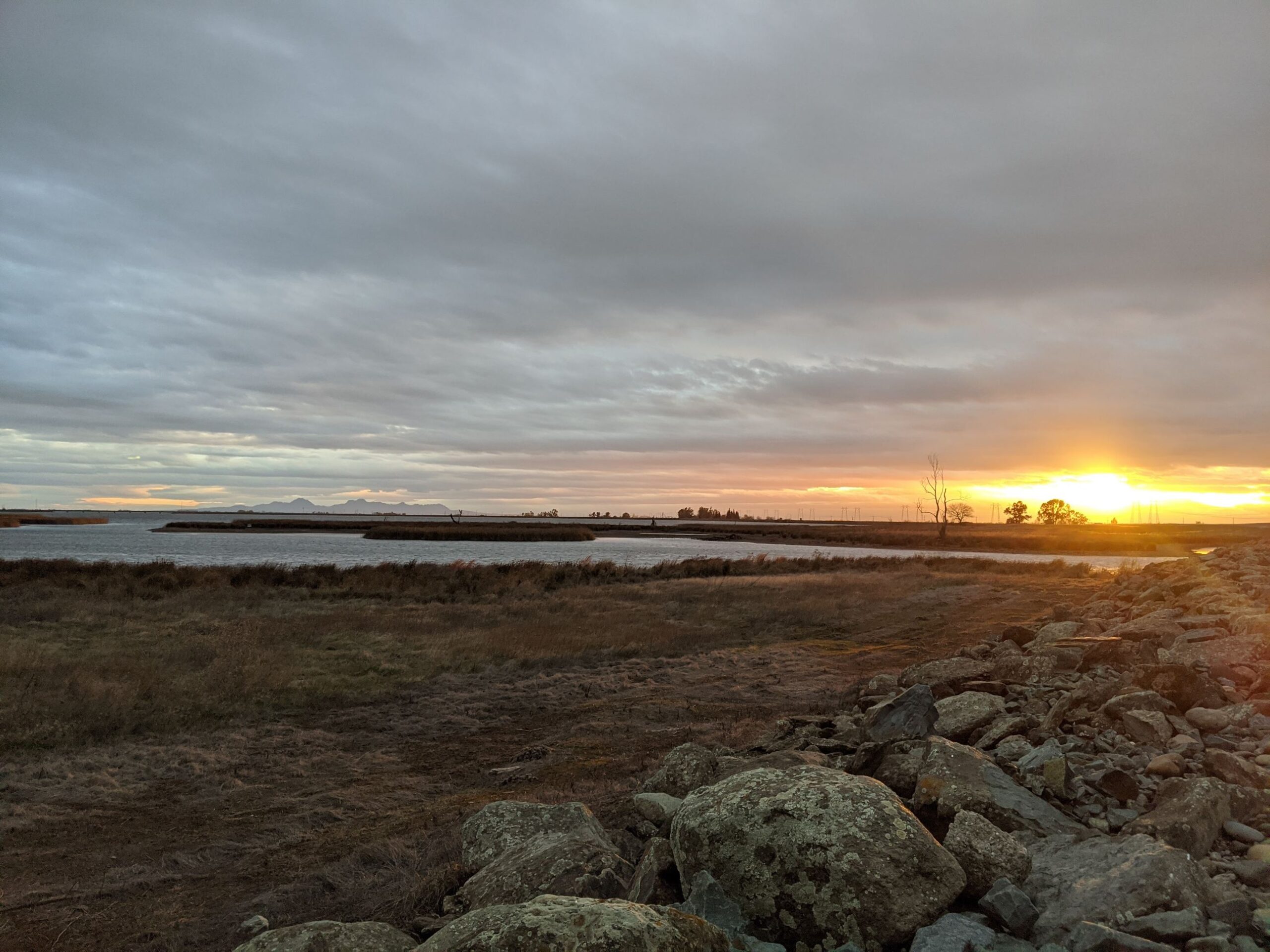 A photograph of sunset over a shallow estuary